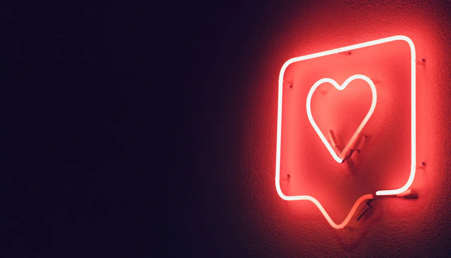 Ein weißes Neon-Herz in einer Sprechblase